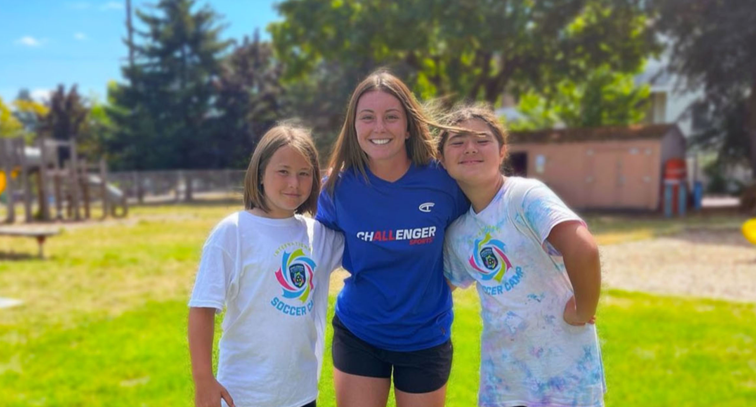 Happy coach with young soccer summer campers