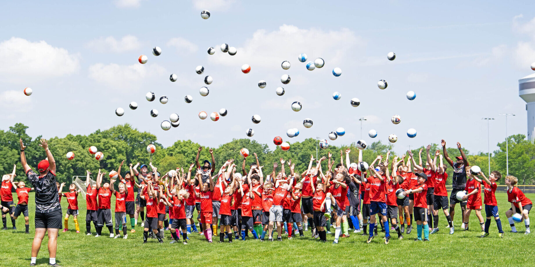 Soccer celebration - children on camp throwing soccer balls in the air
