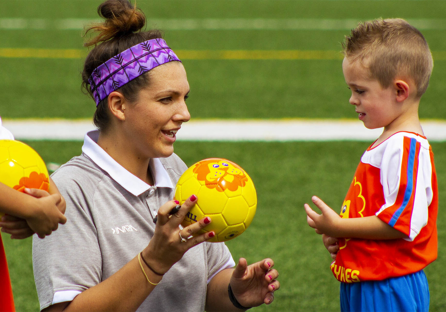 TinyTykes coach talking to a young player